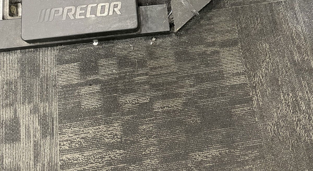Carpet tile under gym equipment, before cleaning